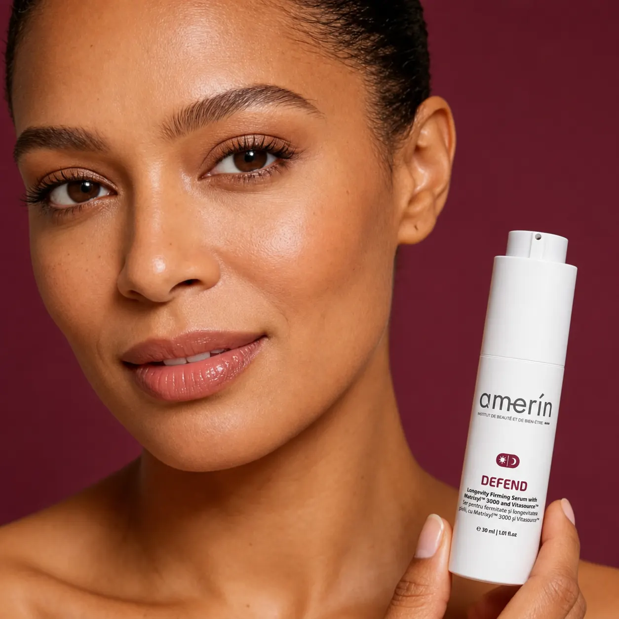 Woman holding amerín DEFEND serum on a burgundy background