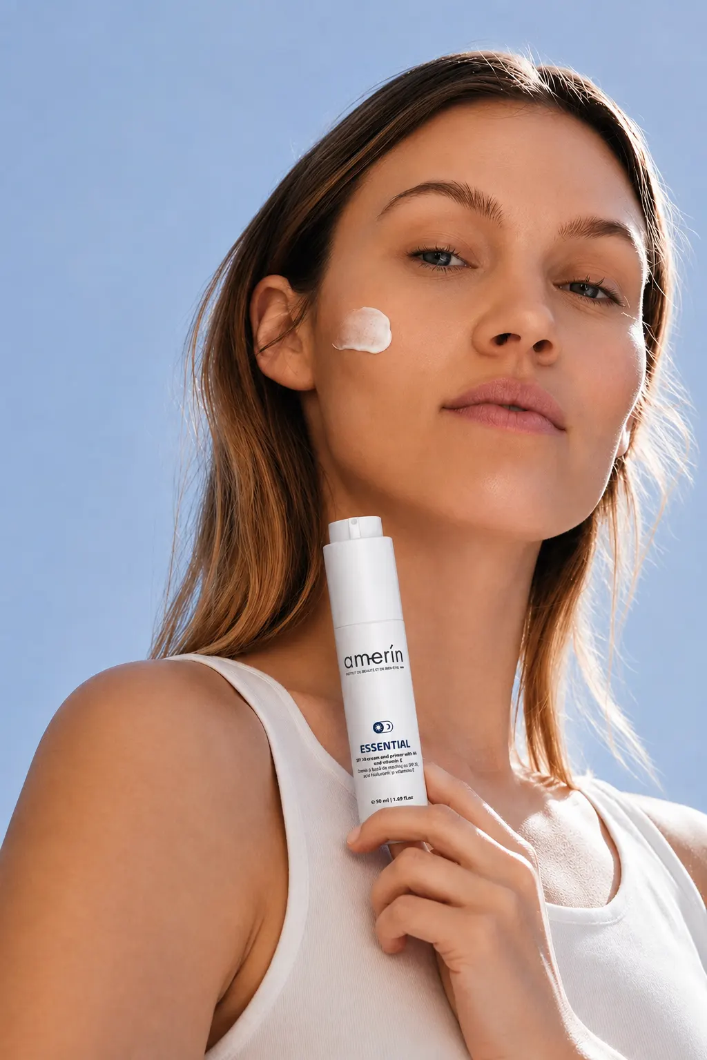 Woman with a dot of cream holding amerín ESSENTIAL SPF30